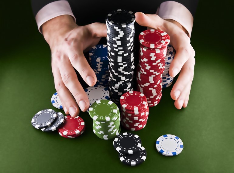 Die Hände strecken sich nach einem Haufen Chips aus