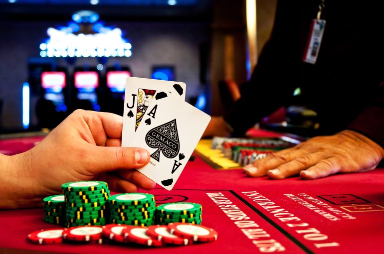Ein Spiel von Blackjack-Chips Bube und Pik-Ass auf den Händen