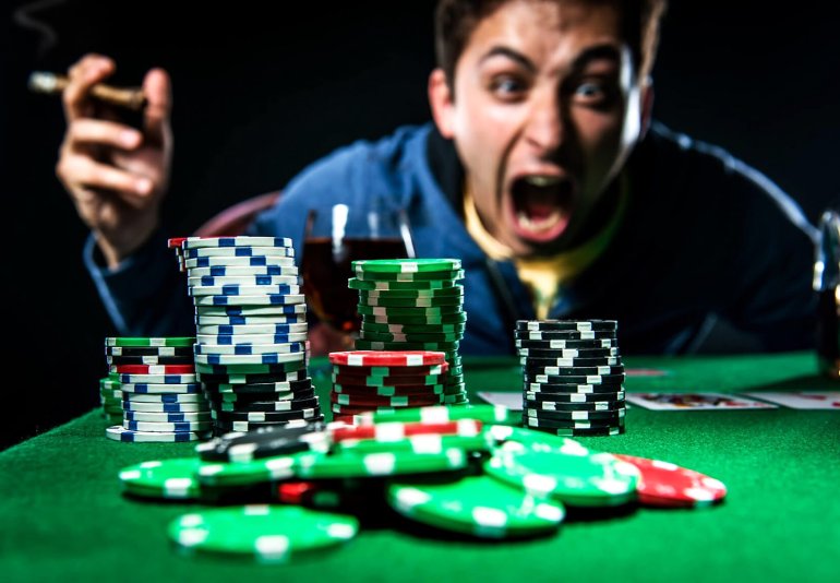 Ein Mann schreit im Zorn mit einer Zigarre in der Hand einen Stapel Chips an