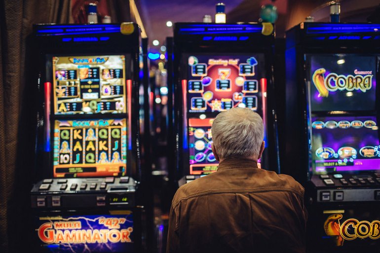 Ein älterer Mann an einem Spielautomaten