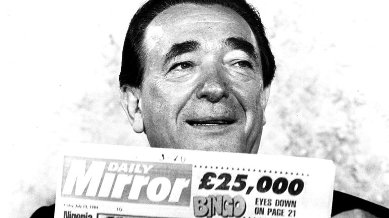 Medienmogul Robert Maxwell mit einer Zeitung in der Hand